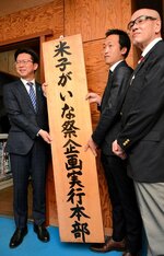 本部の看板を取り付ける（左から）伊木市長、橋尾本部長、鶴田実行委員長＝１７日、米子市道笑町１丁目