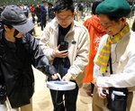 鳥取県ゾーンの「鳥取無限砂丘」で虫眼鏡型デバイスを手に鳥取の魅力を探す来場者＝４月１３日、大阪市此花区の大阪・関西万博会場