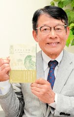 １１種の動物との触れ合いを描いた「カラスと少年」を手にする飯塚さん