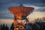 　夕暮れの空を背景に、オレンジ色に照らし出された国立天文台水沢ＶＬＢＩ観測所の口径２０メートル電波望遠鏡。ブラックホールや天の川銀河などを観測してきた＝２０２３年１１月、岩手県奥州市
