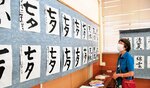 子どもたちの書道作品を鑑賞する来場者