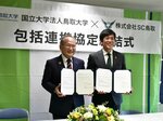 協定書を手にする（左から）中島学長と塚野社長＝１８日、鳥取市蔵田のＡｘｉｓバードスタジアム