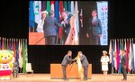 中村知事（中央左）からねんりんピックの大会旗を受け取る平井知事＝３１日、松山市の愛媛県民文化会館