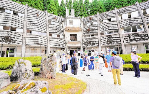 山村のモダニズム建築の傑作と評価されるプラザ佐治。写真は２０２２年７月のシンポジウムで見学する参加者たち
