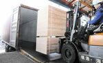 コンテナに積み込まれる住宅用構造合板＝１０日、境港市昭和町