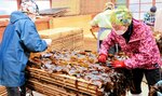生のワカメを網板の上に広げる女性ら