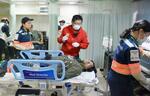 　船内で行われた訓練で、けが人役の男性（下）に声をかける稲葉基高医師（中央）＝３月、愛媛県今治市沖