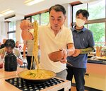 ゆでたてのうどんを試食する参加者