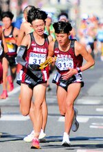 男子　鳥取城北は１区村尾（左）が区間２３位の力走を見せ、２区辻にたすきをつなぐ＝京都市内