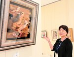 紙を幾重にも重ねた作品を紹介する泉さん
