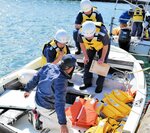 ライフジャケットを入念に確認する署員＝２日、香美町香住区の香住漁港東港