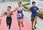 初優勝をつかんだ宇治公子（中央）。宙さん（右）と希さん（左）と手をつないでフィニッシュした＝１４日、米子市のどらドラパーク米子陸上競技場