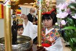 誕生仏に甘茶をかける子どもたち＝１８日、倉吉市のエースパック未来中心