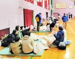 避難して毛布で暖を取るなどする住民＝１日午後６時５５分、新温泉町浜坂の浜坂中体育館