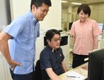 かりゆしウエアで仕事をする木村社長（左）と社員＝１日、境港市渡町の海産物のきむらや