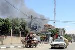 　７日、イスラエル軍による空爆で煙が上がる中、パレスチナ自治区ガザの最南部ラファから避難する人々（ゲッティ＝共同）