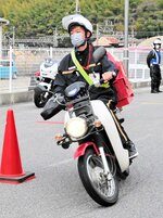 配達用のバイクでコーンの間を走行する配達員