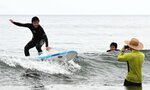 サーフボードの上に立ち、波に乗る生徒＝１１日、鳥取市青谷町青谷の青谷海岸