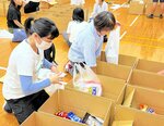 食品などを箱に詰める麦の会のメンバー（手前）ら