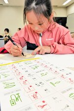 ヒエログリフで名前や日付を書く参加者＝２１日、鳥取市の鳥取県立博物館
