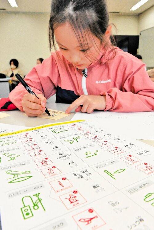 ヒエログリフで名前や日付を書く参加者＝２１日、鳥取市の鳥取県立博物館