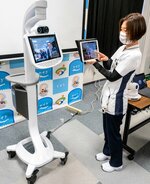 端末を操作し、カート型のシステム機器（左）を自在に動かす看護師