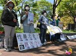 フラワーデモで、花を手にメッセージを掲げる参加者ら＝９日、鳥取市のＪＲ鳥取駅北口