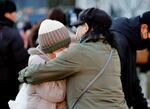 　「１・１７のつどい」の会場で、涙を流し抱き合う女性たち＝１７日午前、神戸市中央区の東遊園地