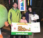 ２５０万人目の来館者となり、佐藤館長（左）から記念品を受け取った岡崎さん親子