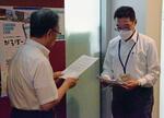 　北九州市芸術文化振興財団に署名を提出する市民有志の代表者（左）＝１７日午前、北九州市