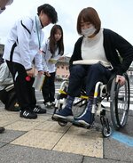 車椅子の車輪が引っかかりやすい箇所を確認する参加者ら＝２６日、鳥取市のＪＲ鳥取駅前