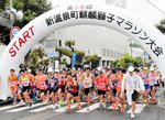 上位を目指し、勢いよくスタートするランナー＝２５日、新温泉町役場前