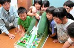 模型を使って、土石流発生時の砂防ダムの効果を学ぶ児童たち＝１３日、鳥取市佐治町福園の佐治小