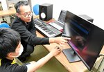 中学生に「ＤＡＷ」の使い方を教える三上代表（奥）。「若者がデジタルアートに触れるきっかけにしたい」と意気込む＝２日、倉吉市住吉町の市文化活動センター