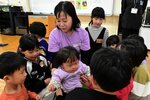赤ちゃんと楽しそうに触れ合う児童ら