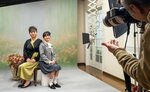 カメラマンに応え、笑顔でポーズをとる親子＝１１日、米子市両三柳