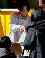 　自身のチョコブランドが出店したスタジアムで、商品を手渡す清水慶記さん＝２０２５年２月、前橋市