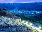 町並みを眼下にライトアップされた三の丸石垣＝７月３１日夜、島根県安来市広瀬町富田
