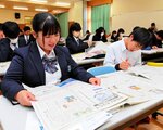 ページの特徴などを聞き、新聞をめくる生徒＝２５日、北栄町由良宿の鳥取中央育英高