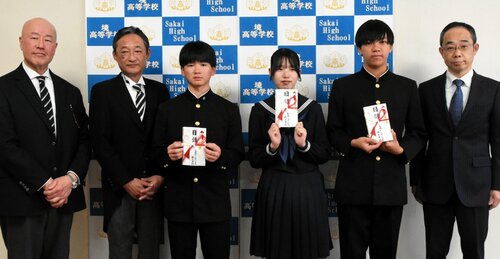 奨学金の目録を手にする生徒ら