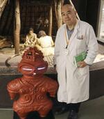 　金子昭彦さんと遮光器土偶のマスコット＝盛岡市の岩手県立博物館