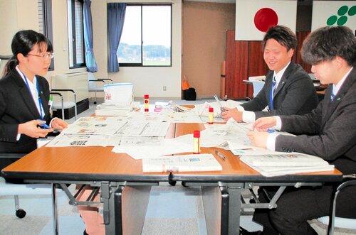 相談しながらオリジナルのスクラップ新聞作りに取り組む新入職員ら