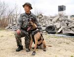 　警備犬「ジャスミン」とハンドラーの２等空曹志賀敬祐さん＝３月、埼玉県の航空自衛隊入間基地