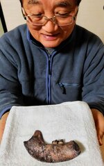 完成した「夜見ケ浜人」のレプリカを手にする根平さん＝境港市東本町