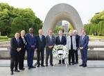 　原爆慰霊碑の前で写真に納まる、エルダーズの参加者と広島市の松井一実市長（中央）＝１３日午後、広島市の平和記念公園