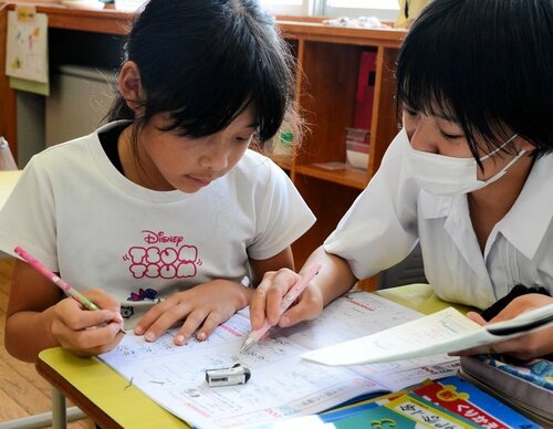 児童に漢字を教える高校生（右）
