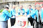 【振る舞い】鏡開きを行う関係者ら。ショウブの葉の入ったコップに日本酒が注がれ来場者に振る舞われた
