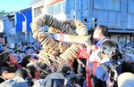 広田一恭倉吉市長（中央右）が雌雄のツボグチに栓木をはめ込むのを合図に大綱を引き合う市民ら＝５日、鳥取県倉吉市明治町