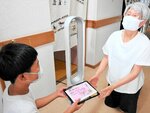 児童から弁当とメッセージカードを受け取る高齢者