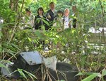 山林で不法投棄されたごみを確認する参加者ら＝２４日、岩美町相山